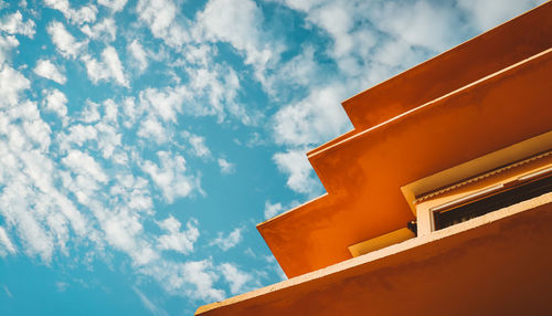 Low angle view of building against blue sky during sunny day