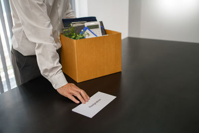 Midsection of man using digital tablet while sitting on table