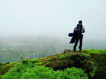 Man standing on mountain against sky