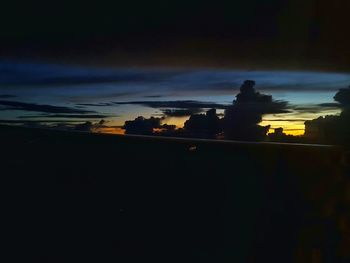 Low angle view of silhouette trees against sky