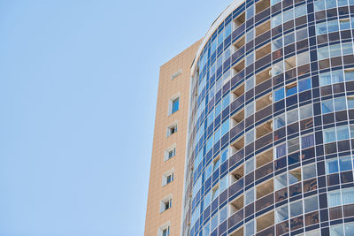 Low angle view of modern building against clear blue sky