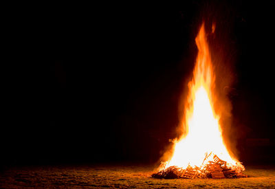Close-up of bonfire on beach at night
