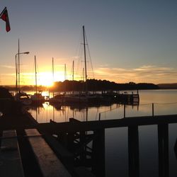 Sailboats in sea at sunset