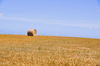 Hay bales on field against sky