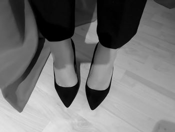 Low section of woman standing on hardwood floor