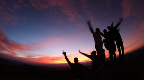 Silhouette people against sky at night