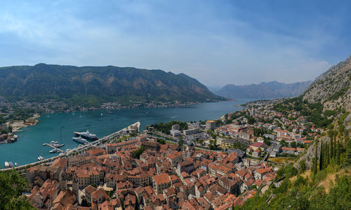 High angle view of townscape by sea against sky