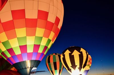 Low angle view of illuminated hot air balloons against clear sky during festival