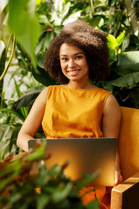 Portrait of a smiling young woman sitting outdoors