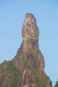 Low angle view of rock formation against clear blue sky
