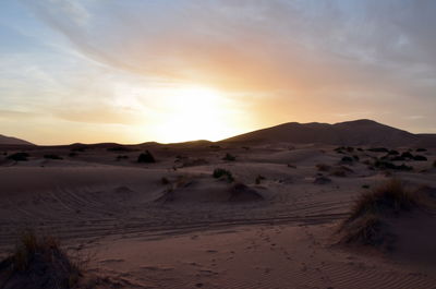 Scenic view of desert against sky during sunset