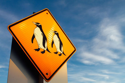 Low angle view of road sign against sky