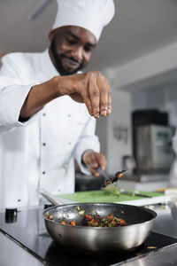 Midsection of man preparing food in kitchen