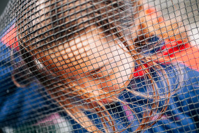 Close-up of girl seen through net