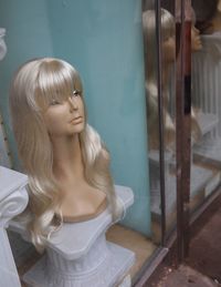 Close-up of young woman standing against wall