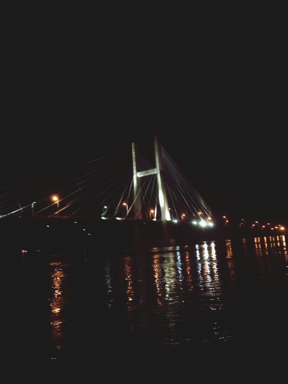 night, illuminated, water, reflection, built structure, architecture, clear sky, copy space, river, dark, lighting equipment, waterfront, street light, transportation, bridge - man made structure, building exterior, connection, city, outdoors, light - natural phenomenon