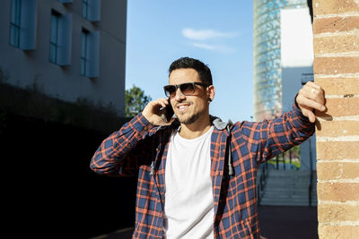 Smiling man talking on phone outdoors