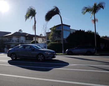 Cars on road by building against sky