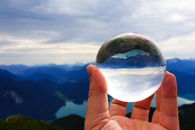 Person holding ice cream against mountain range