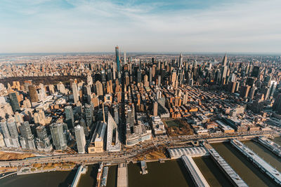 Aerial view of buildings against cloudy sky