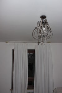 Electric lamp hanging on ceiling at home