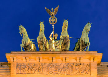 Low angle view of angel statue against blue sky