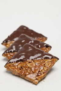 Chocolate dipped and caramelised almonds on white background