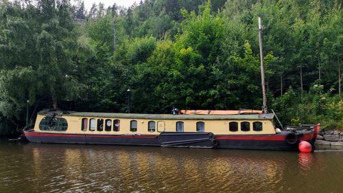 View of boats in river against trees