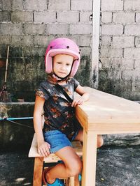 Girl wearing helmet while sitting at table