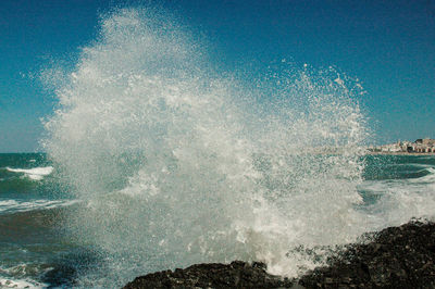 Waves splashing in sea against sky