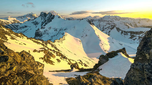 Scenic view of snowcapped mountains against sky during sunset