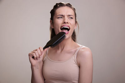 Close-up of young woman holding knife against wall