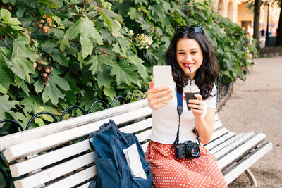 Smiling young woman using smart phone outdoors