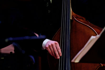 Midsection of man playing cello