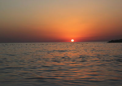 Scenic view of sea against orange sky