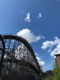 Low angle view of ferris wheel against blue sky