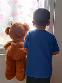 Rear view of man with teddy bear