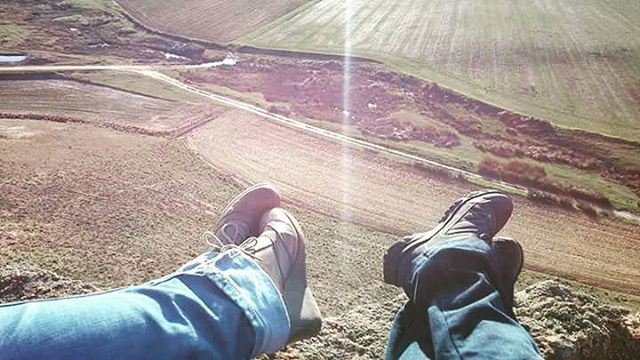 low section, person, shoe, personal perspective, lifestyles, men, human foot, jeans, leisure activity, standing, high angle view, footwear, field, landscape, unrecognizable person, outdoors, part of