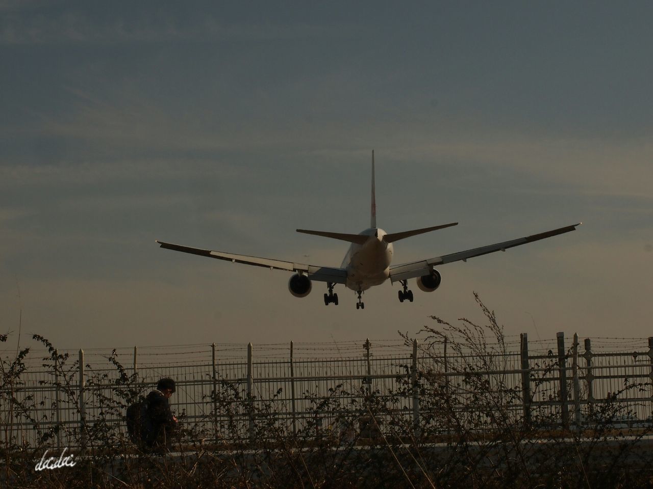 LOW ANGLE VIEW OF AIRPLANE FLYING AGAINST SKY AT SUNSET