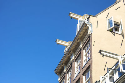 Low angle view of buildings against clear blue sky