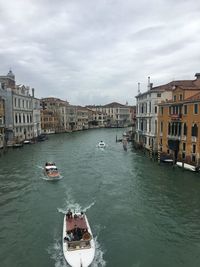 Boats in canal amidst buildings in city