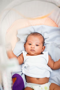 High angle view of cute baby boy sleeping on bed at home