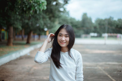 Smiling young woman standing outdoors