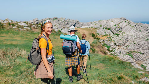 Happy young woman looking camera hiking with her grandparents