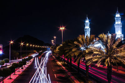 Light trails on road against sky at night