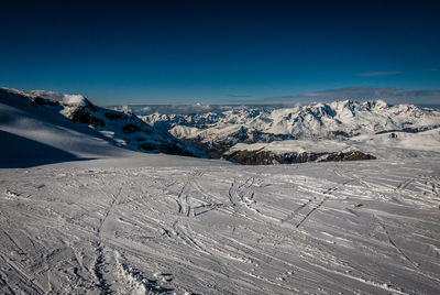 Scenic view of snowcapped mountains against blue sky