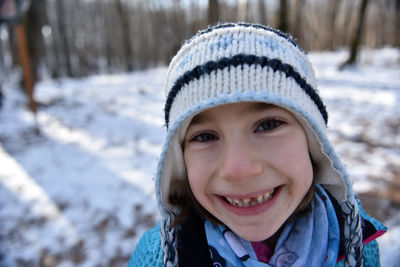 Smiling kid in the forest in wintertime