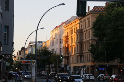 Traffic on road amidst buildings in city against sky