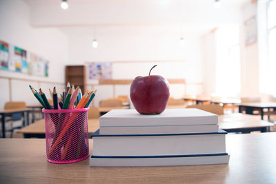 Close-up of apple on table against wall at home