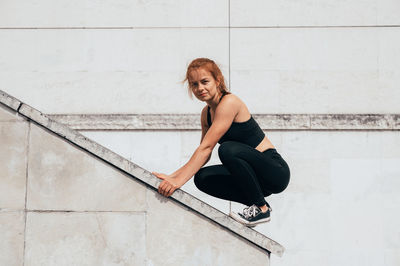 Side view of athlete crouching on railing